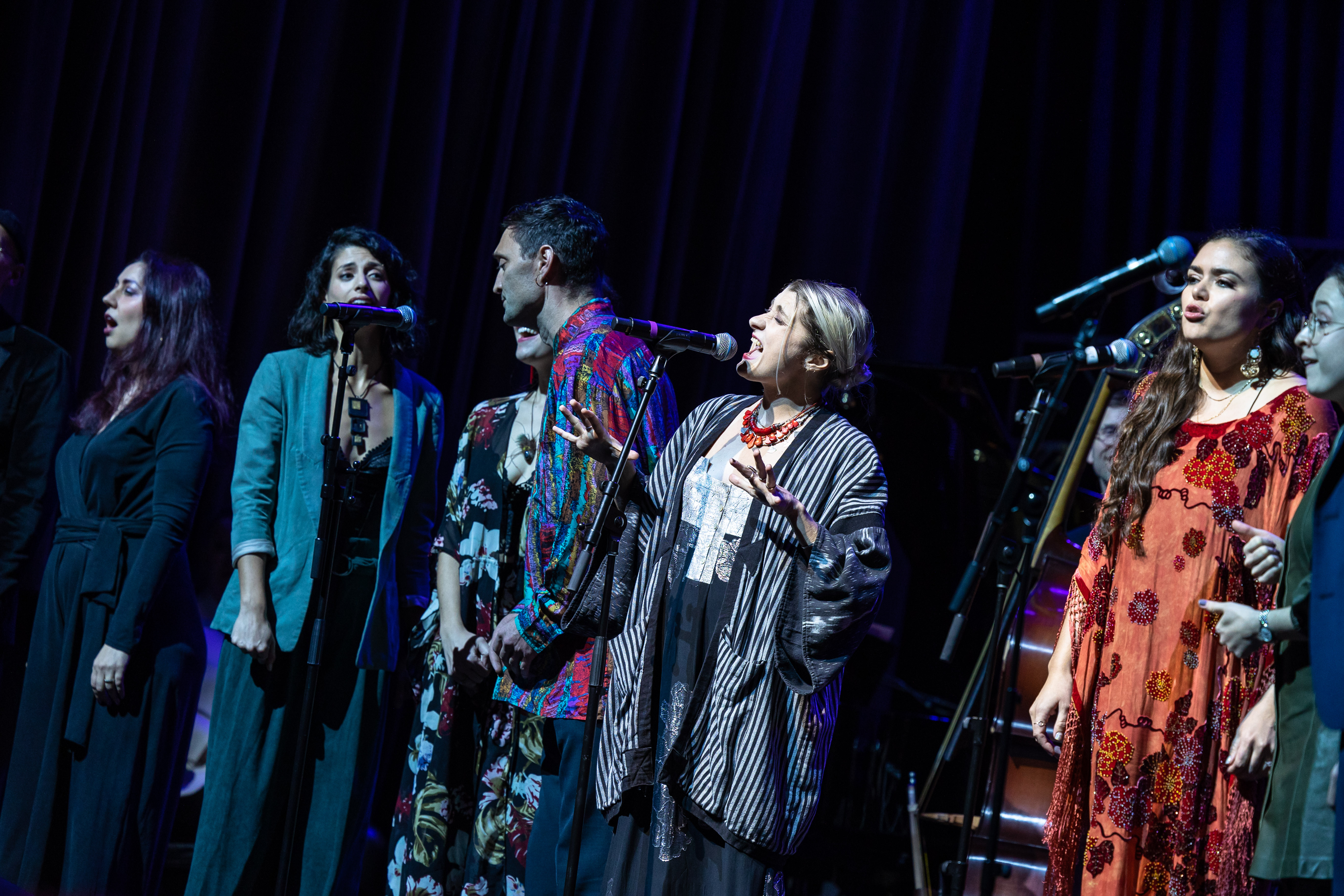 people onstage with person singing in foreground