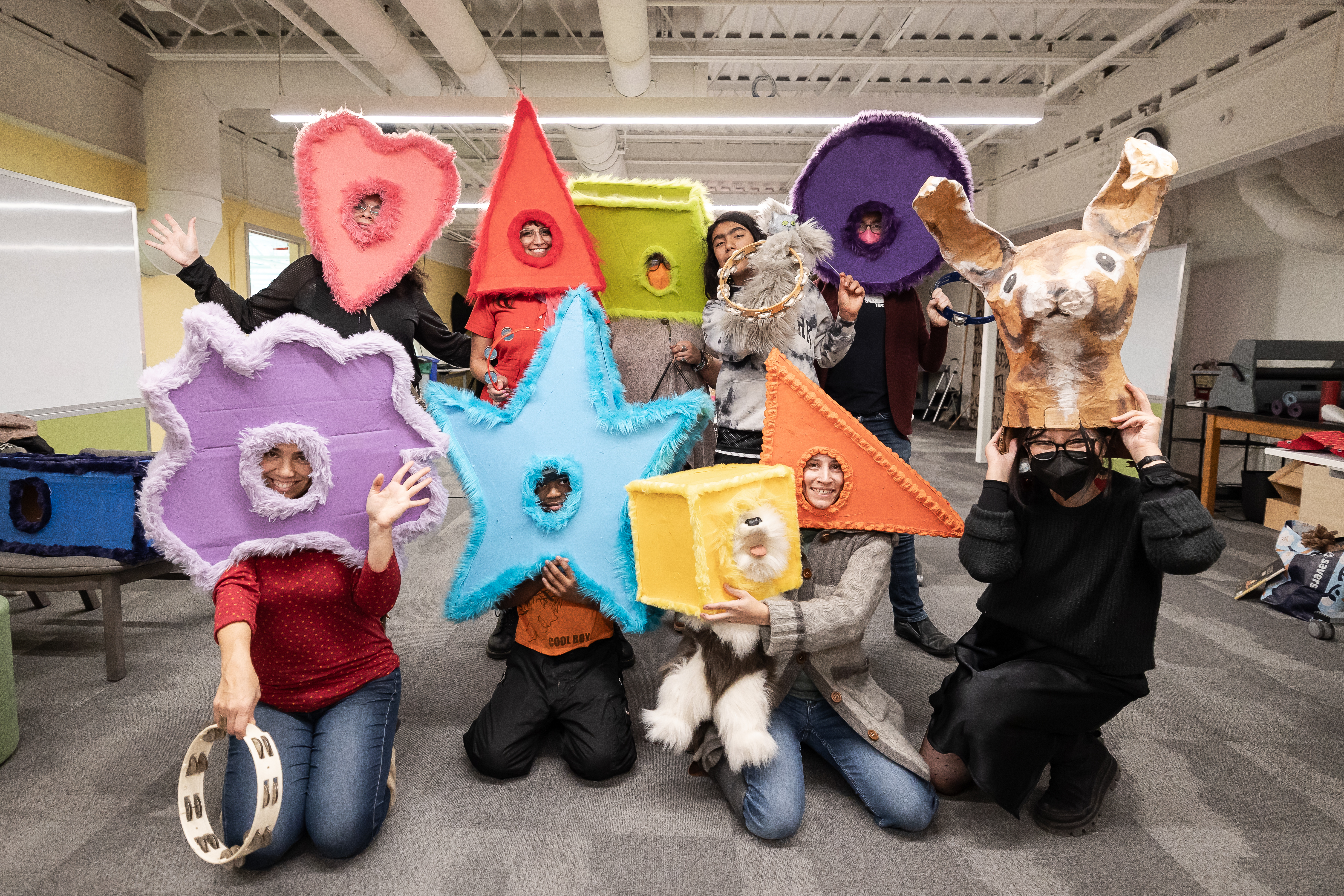 Community members pose with handmade masks at an artists market at Springboard for the Arts