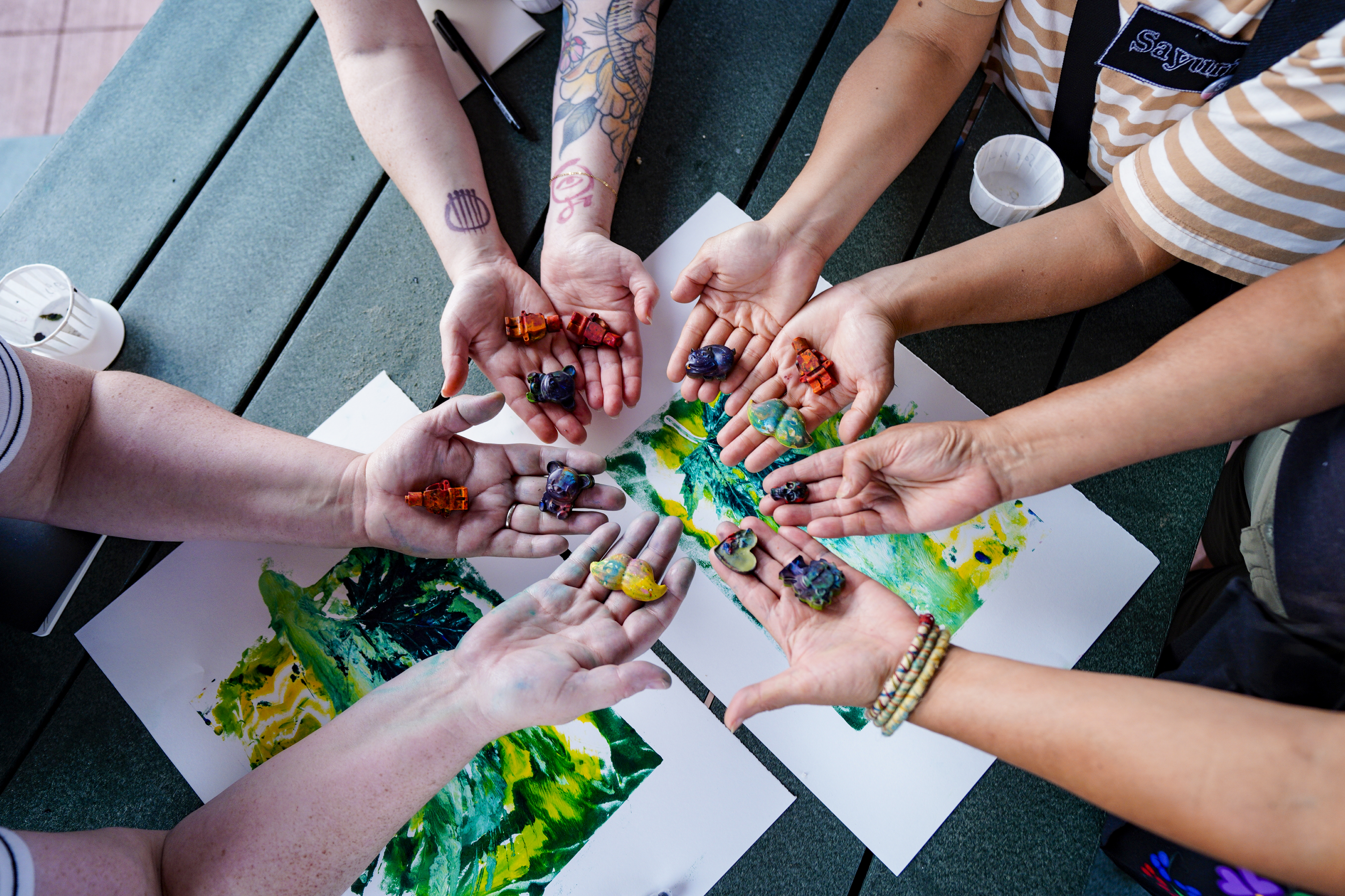 Artists' hands display recycled crayon wax sculptures at the Rural Futures Summit, July 2025