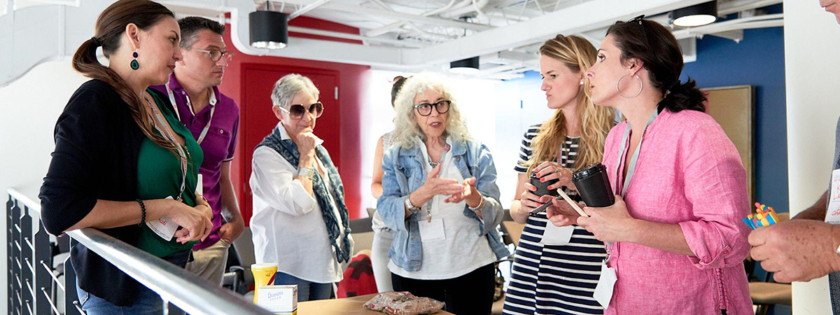 A group of five people are gathered in conversation